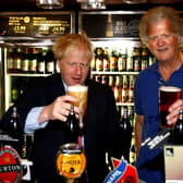 Boris Johnson (L) poses with a pint of beer as he talks with JD Wetherspoon chairman Tim Martin during his visit to their Metropolitan Bar in London, on July 10, 2019.