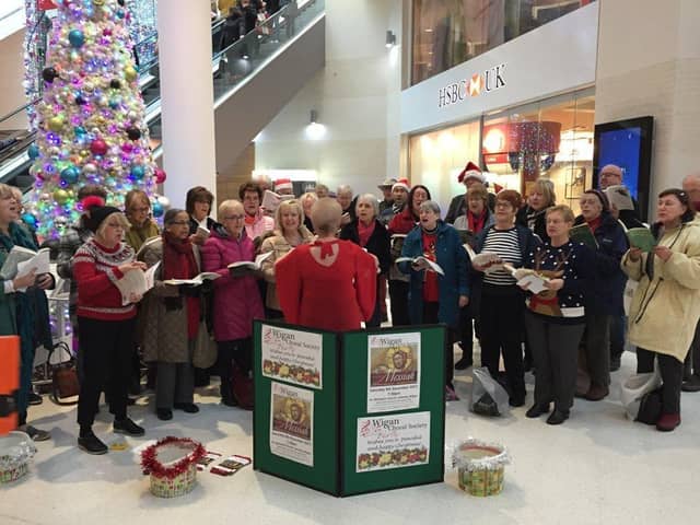 Members of WIgan Choral Society serenading Christmas shoppers in the Grand Arcade in per-pandemic times