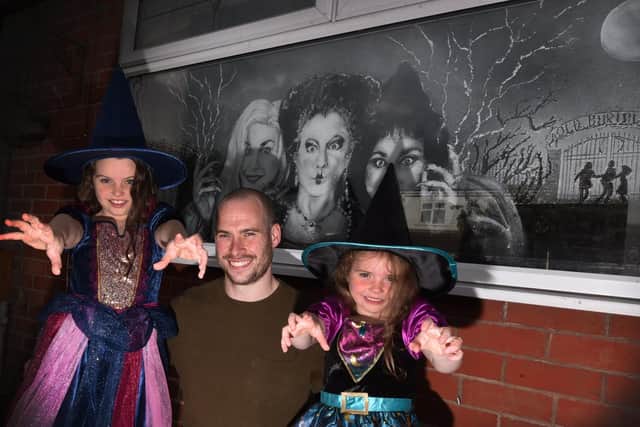 Snow Graffiti artist Scott Wilcock has created window displays for Halloween at his home in Ashton-in-Makerfield. Pictured with daughters Maisie, eight, and Alice, five, right.