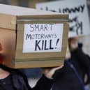 Demonstrators protesting against smart motorways march with coffins across Westminster Bridge to Parliament Square in London