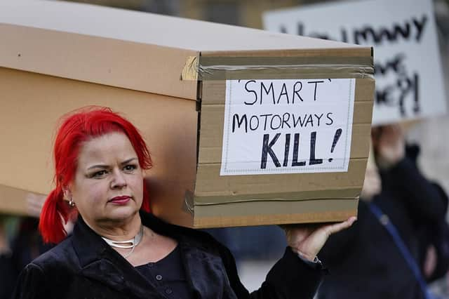 Demonstrators protesting against smart motorways march with coffins across Westminster Bridge to Parliament Square in London