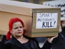 Demonstrators protesting against smart motorways march with coffins across Westminster Bridge to Parliament Square in London