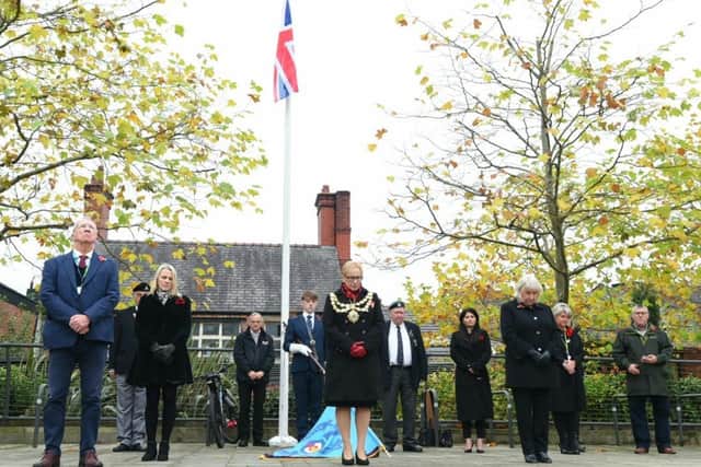 Wigan Council leaders observe the two minutes' silence in Believe Square
