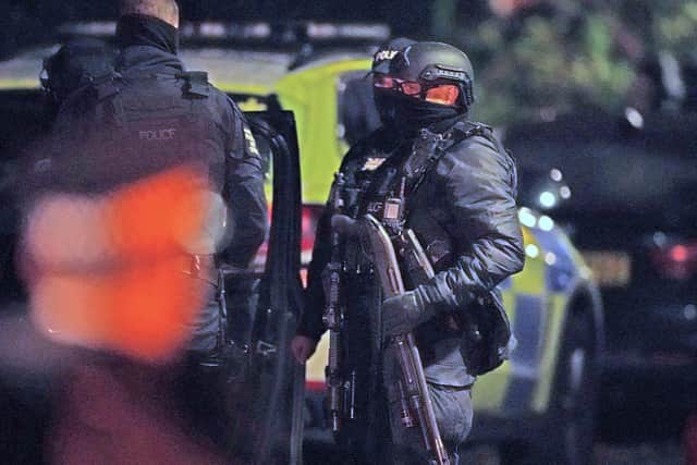 A armed police officers holds a breaching shotgun, used to blast the hinges off a door, at an address in Rutland Avenue in Sefton Park, after an explosion at the Liverpool Women's Hospital killed one person and injured another. Three men have been arrested under the Terrorism Act.