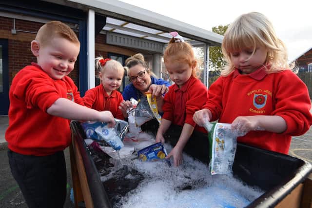 Nursery children helping to clean the crisp packets