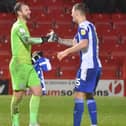 Jamie Jones and Jason Kerr celebrate Latics overcoming Accrington on penalties