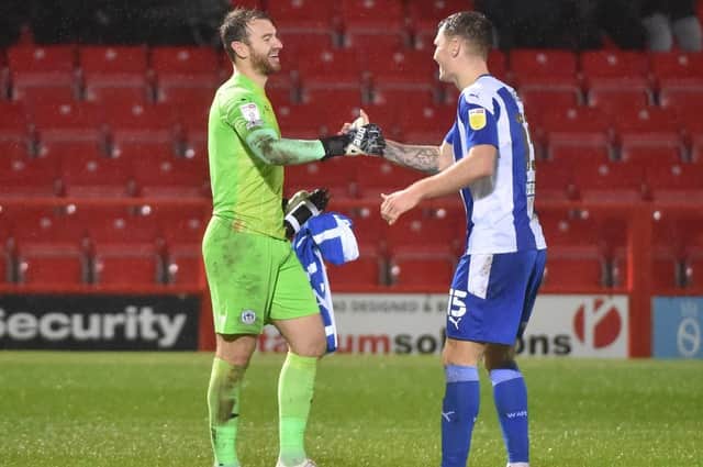 Jamie Jones and Jason Kerr celebrate Latics overcoming Accrington on penalties