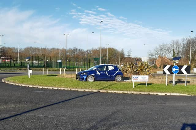 The battered car sitting on the roundabout