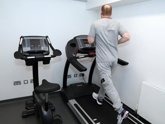 A prisoner, who has already served 18 years and has another seven until his release, completes a 5km run in one of the house block's 'cardio rooms'