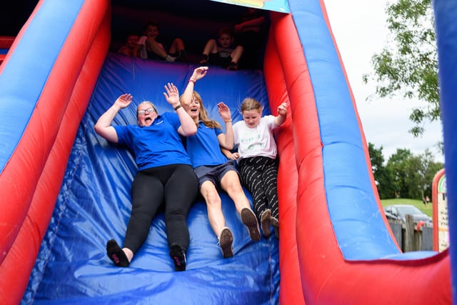 Staff from Wigan Council at Norley Hall family fun day enjoy a go on the inflatable slide. Photo: Kelvin Stuttard
