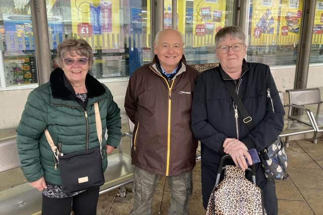 (L-R) Ann and Pete Quigley with Brenda Wainwright standing at a bus stop on Market Street, Atherton