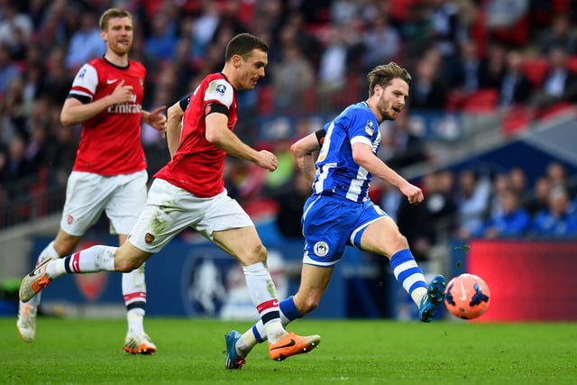 Nick Powell of Wigan Athletic passes the ball under pressure from Thomas Vermaelen of Arsenal during the FA Cup Semi-Final match between Wigan Athletic and Arsenal at Wembley Stadium on April 12, 2014 in London, England.