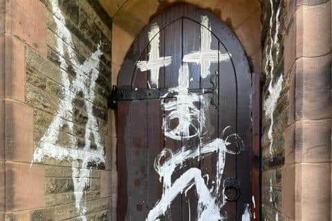 Vile graffiti daubed on the front doors to St Mark's Church