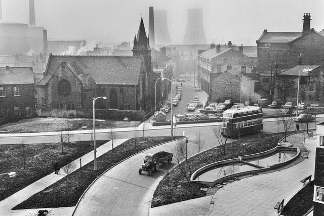 A view across the bottom end of Millgate and Rodney Street towards Chapel Lane with Trinity Methodist Church on the left and Wigan gas works and Westwood cooling towers in the background in the late 1960s.