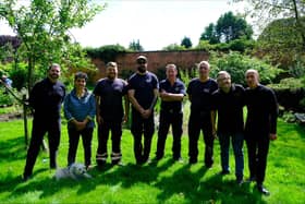 Creative directors Al and Al, Dr Sylvia Travers, and Councillor Chris Ready stand with the gardening team at Haigh Hall