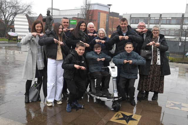 Jack with family and friends in a rain-lashed Believe Square