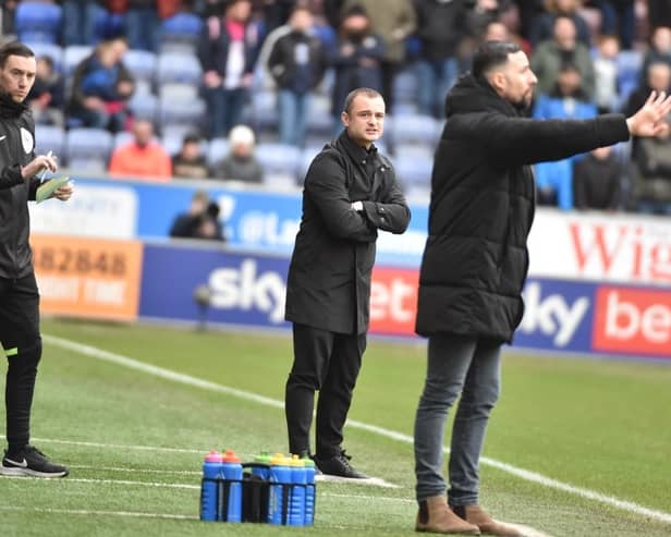 Huddersfield interim head coach Narcís Pelach tries to make his point as Shaun Maloney watches on