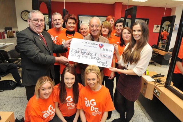 Carl Sharpe, left, and Mary McLaughlin, right, from The Christie accept a £865 cheque from Philip Halliwell, centre, and staff from Norman and Philip Hairdressers, Wigan.  Philip was getting treatment for cancer and the funds were raised from a coffee morning selling drinks and cakes