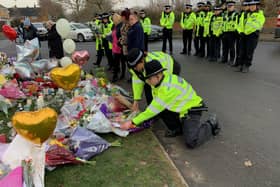 Officers from West Midlands Police lay bouquets of flowers and stood in silence near to the scene in Babbs Mill Park in Kingshurst, Solihull, after the deaths of three boys aged eight, 10 and 11 who fell through ice into a lake