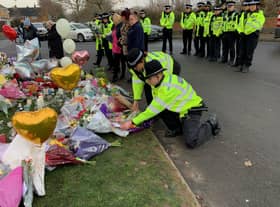 Officers from West Midlands Police lay bouquets of flowers and stood in silence near to the scene in Babbs Mill Park in Kingshurst, Solihull, after the deaths of three boys aged eight, 10 and 11 who fell through ice into a lake
