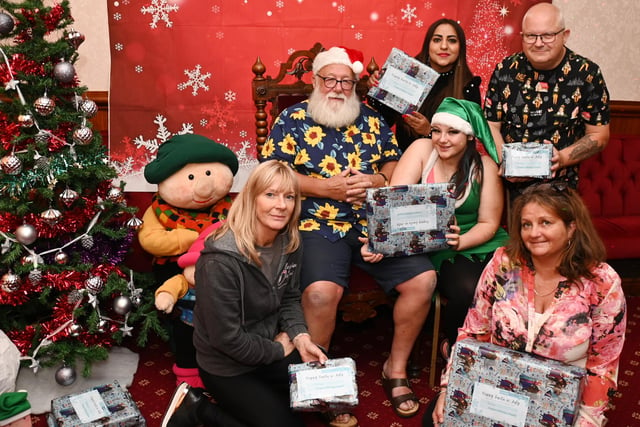 Santa and his elf with event organisers from Blessings in Disguise, Katie Holt (left) Ferdious Habib (back), Sharon Sargent (front right) and Dave Dalton (back right) at the 10th annual Santa in July event organised by the charity.