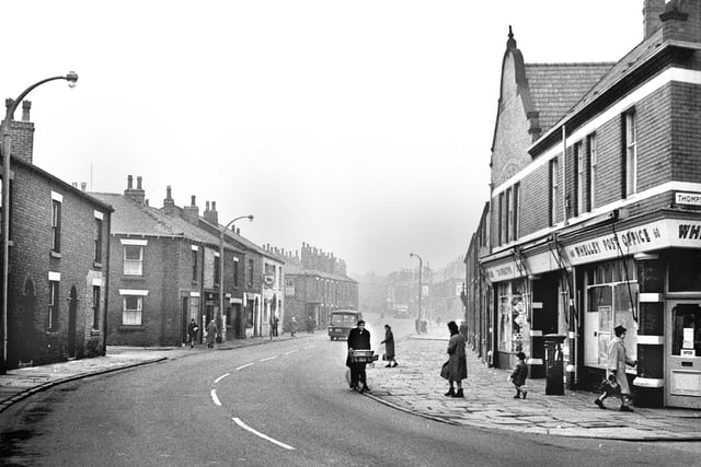 A view of Whelley at the junction with Thompson Street on a misty December day in 1963. Whelley post office is on the right and the George and Dragon pub is in the middle distance on the left of the street.  