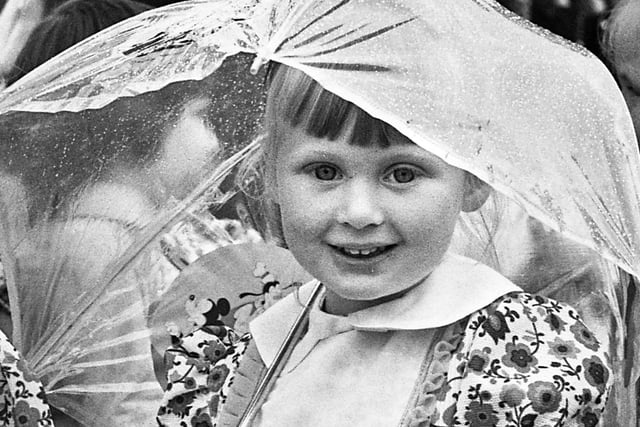 A happy little girl despite the pouring rain on St. Paul's, Goose Green, walking day on Sunday 24th of June 1973.