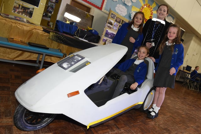 Pupils with the Sinclair C5 electric car produced in 1985 which demonstrates electric cars are not a new invention.