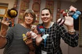 Kim Beardsmore from Age UK Wigan Borough, right, with Kath Lewin, left, from Daisy Chain Stitches,  the group meet every Tuesday afternoon at Clifton Street Community Centre, Poolstock, have been busy making little knitted hats to go on Innocent Smoothie bottles in partnership and raising funds for Age UK, the group have made about 600  so far.