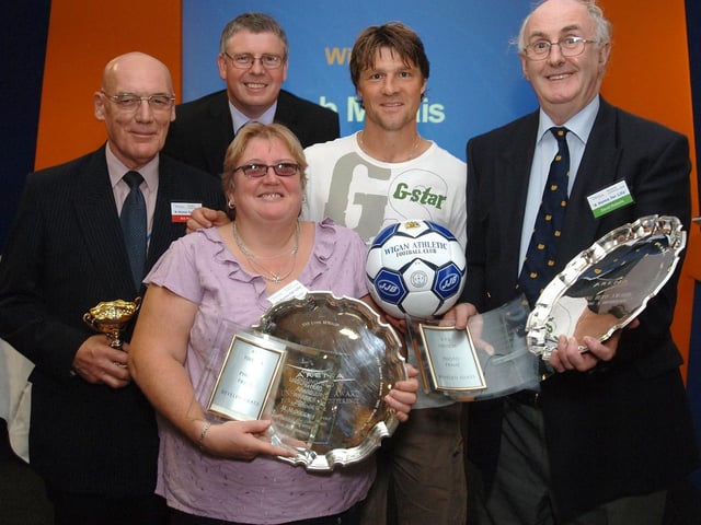 Wigan Athletic captain Arjan De Zeeuw with the prize winners in the Unsung Hero category at the Arena Housing Group Residents' Conference at the JJB Stadium; Bob Marais, left, Mal McDougal and David Roberts with Arena chief executive Graham Eades looking on