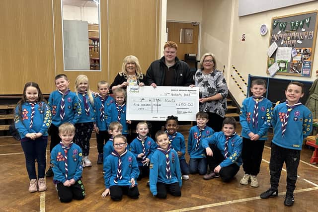 Members of the 3rd Wigan Beaver Scouts collect the £500 cheque from Coun Pat Draper, Labour's prospective candidate for Douglas ward Matt Dawber, and Coun Mary Callaghan
