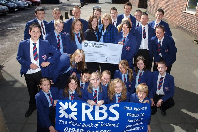 2006 Lesley Brennan, manager of the Ince branch of The Royal Bank of Scotland, and customer service officer Margaret Hope present Deanery High School pupils with a cheque for £1,000 from the bank's Community Cashback charity fund which sees staff members giving up their spare time to help with local projects such as the school's recent bazaar.
