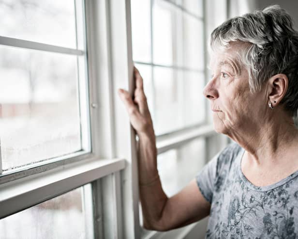 Woman looking out of window with condensation