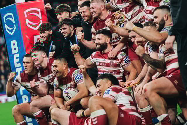 Wigan players celebrates with the Super League trophy.