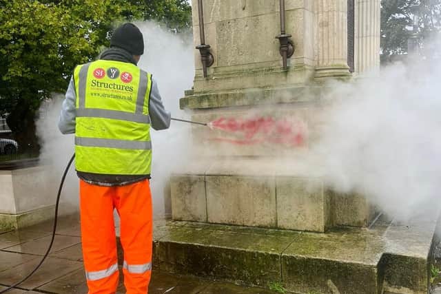 A member of the WJ Structures team blasts the Leigh war memorial graffiti away
