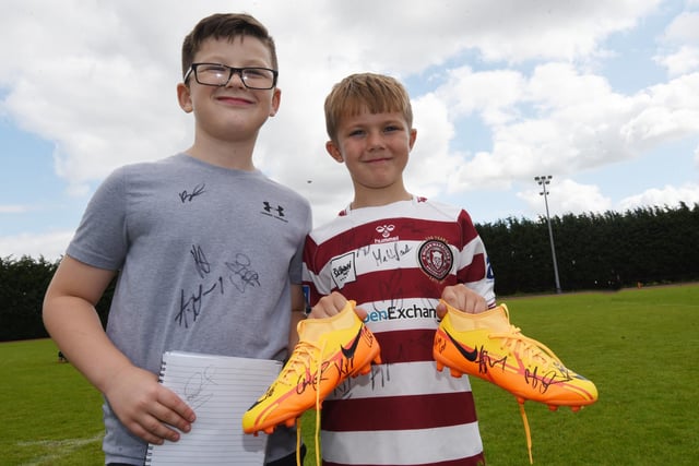 Young fans show off their signed shirts and boots.