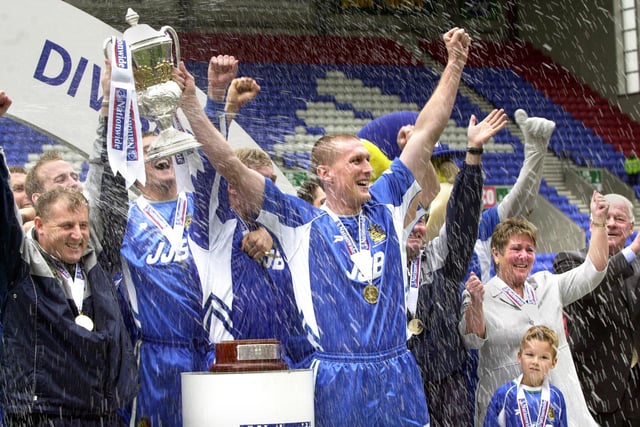 The champagne rains down as manager, Paul Jewell and captain, Jason De Vos, lift the Division 2 championship trophy after beating Barnsley 1-0 with a Tony Dinning goal on Saturday 3rd of May, the last day of the 2002/2003 season. 