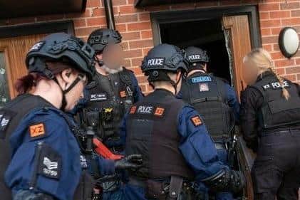 Officers raiding a home on a dawn raid