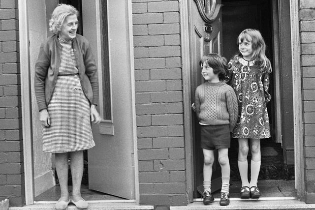 Evelyn Melling on her doorstep and next door her grandchildren, Adrian and Lorraine, in Coppull Lane, Swinley, in December 1974.