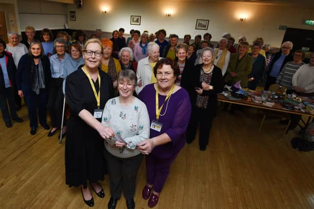 Maureen Holcroft, front left, and Karen Strong, right, from Daffodils Dreams, are presented with a £1,000 cheque by Pauline Clemson, centre, and members of Wigan and Leigh NHS Friendship Club