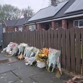 Flowers and toys create a shrine outside the bungalow on Marsh Green