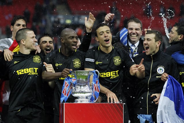 Wigan Athletic players celebrate with the FA Cup after winning the English FA Cup final football match between Manchester City and Wigan Athletic at Wembley Stadium in London on May 11, 2013.