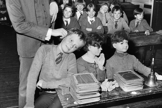 Matthew Newton of Whelley Middle School gets his ear tweaked by the schoolmaster during a lesson in the Victorian classroom on a visit to The Way We Were at Wigan Pier on Tuesday 29th of April 1986.