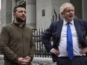 In this image provided by the Ukrainian Presidential Press Office, Ukrainian President Volodymyr Zelenskyy, left, and Britain's Prime Minister Boris Johnson talk during their walk in downtown Kyiv, Ukraine