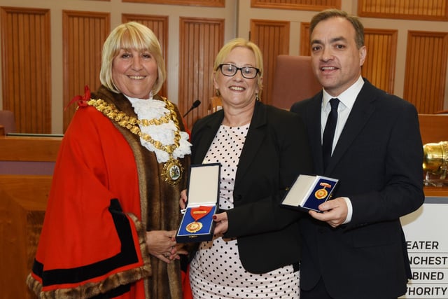 The new Mayor of Wigan Coun Marie Morgan,left, makes a presentation to out-going Mayor of Wigan Coun Yvonne Klieve and her consort and husband Mark Klieve, right.