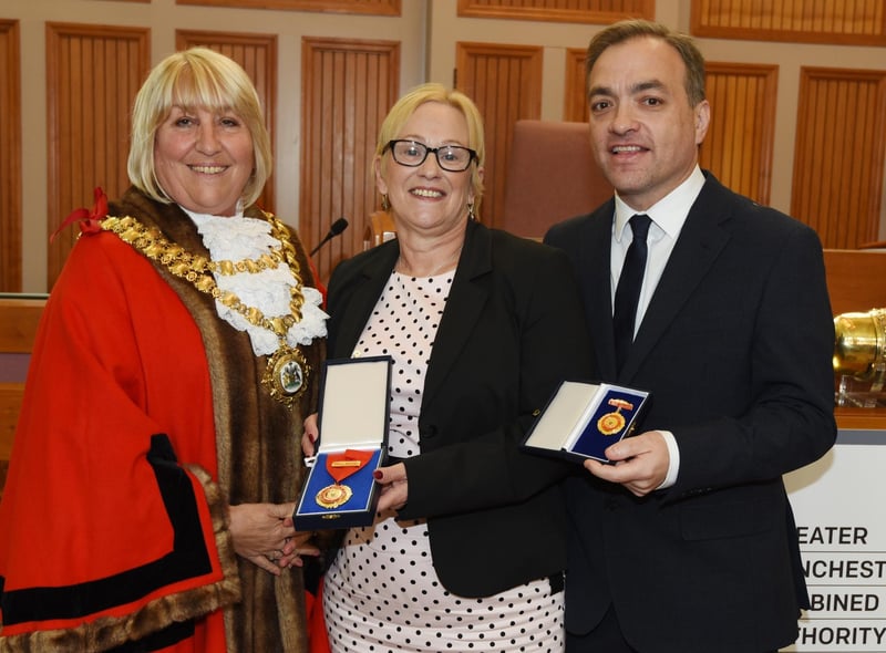The new Mayor of Wigan Coun Marie Morgan,left, makes a presentation to out-going Mayor of Wigan Coun Yvonne Klieve and her consort and husband Mark Klieve, right.