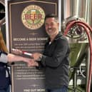 Alex Barlow, chief assessor at The Guild of Beer Sommeliers, presents Joanna Whalley with her certificate