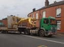 The naked golden statue seemingly does a 'Superman' on the back of a truck through the streets of Wigan as it is removed