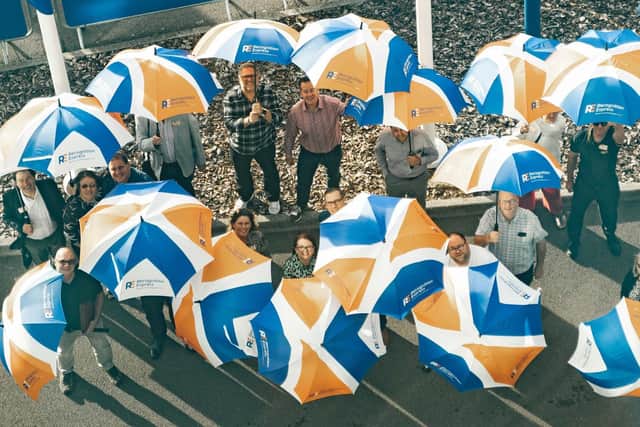 Recognition Express bosses celebrate the rebrand with umbrellas bearing the new logo