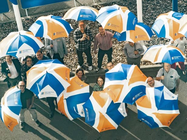 Recognition Express bosses celebrate the rebrand with umbrellas bearing the new logo